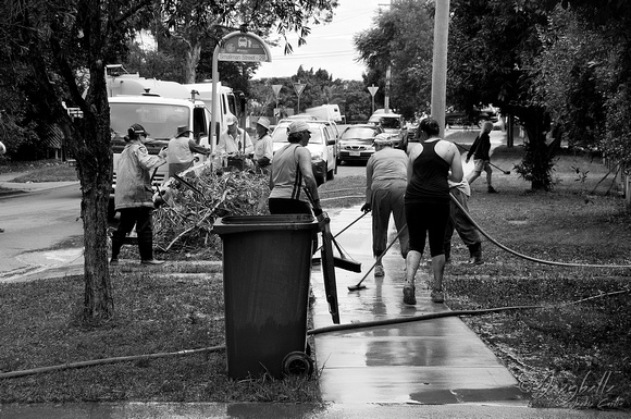 14.1.2011 A team of sweepers clean the sidewalk on Smallman St Bulimba BW